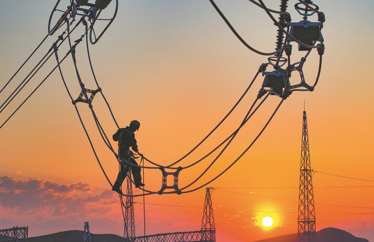 An employee inspects cables before the operation of a power line in Hinggan League